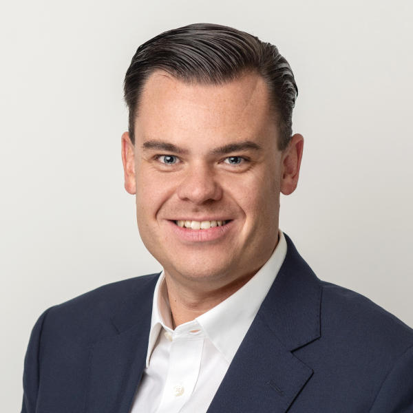 An image of Liam Hosie wearing a suit jacket and shirt. He is smiling at the camera. An image of Liam Hosie wearing a suit jacket and shirt. He is smiling at the camera.