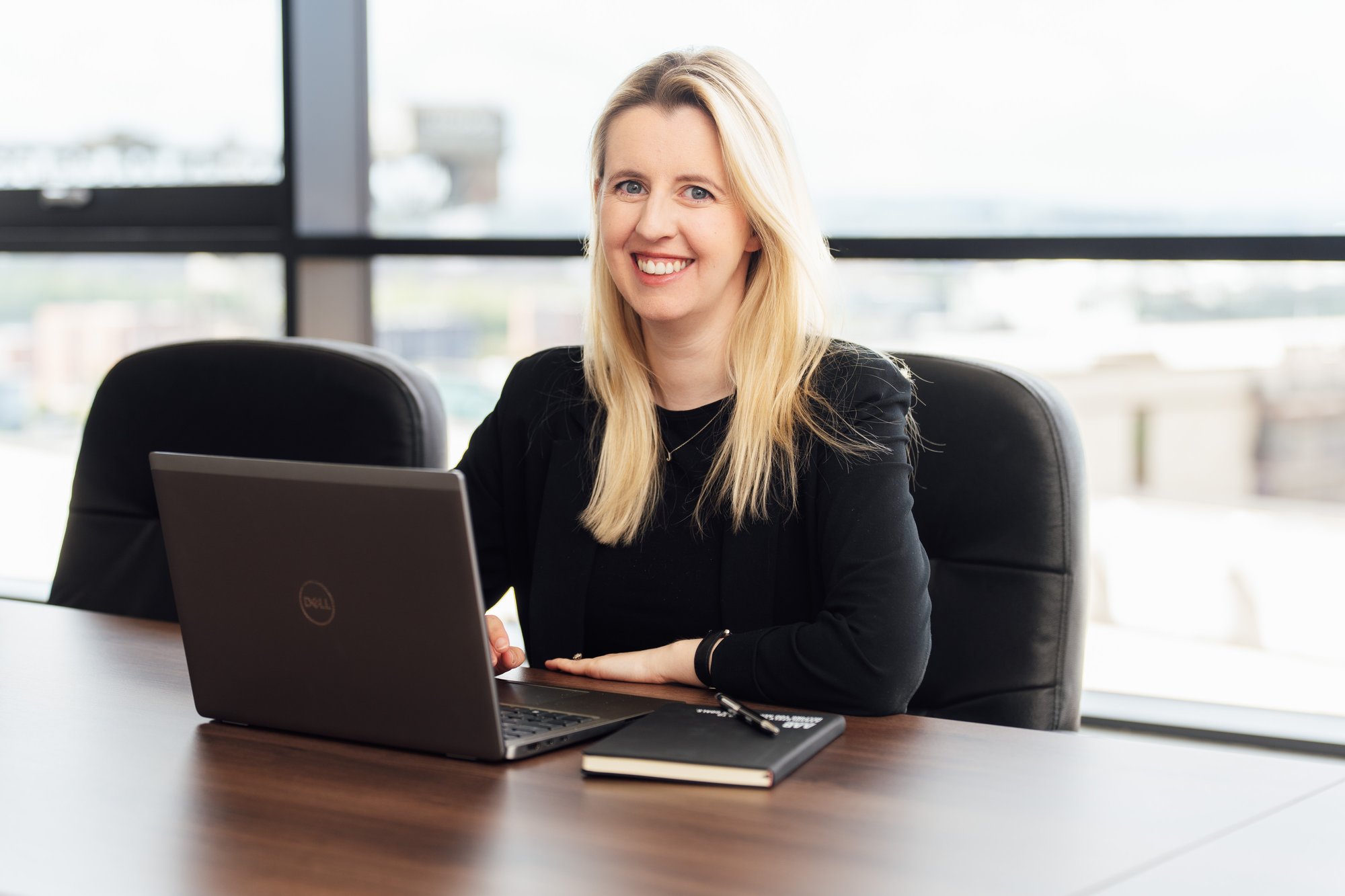 An image of an AAB employee in the office sitting at a desk on her laptop.