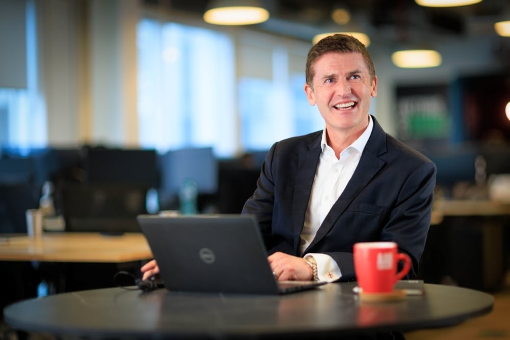 AAB employee smiling at desk on laptop