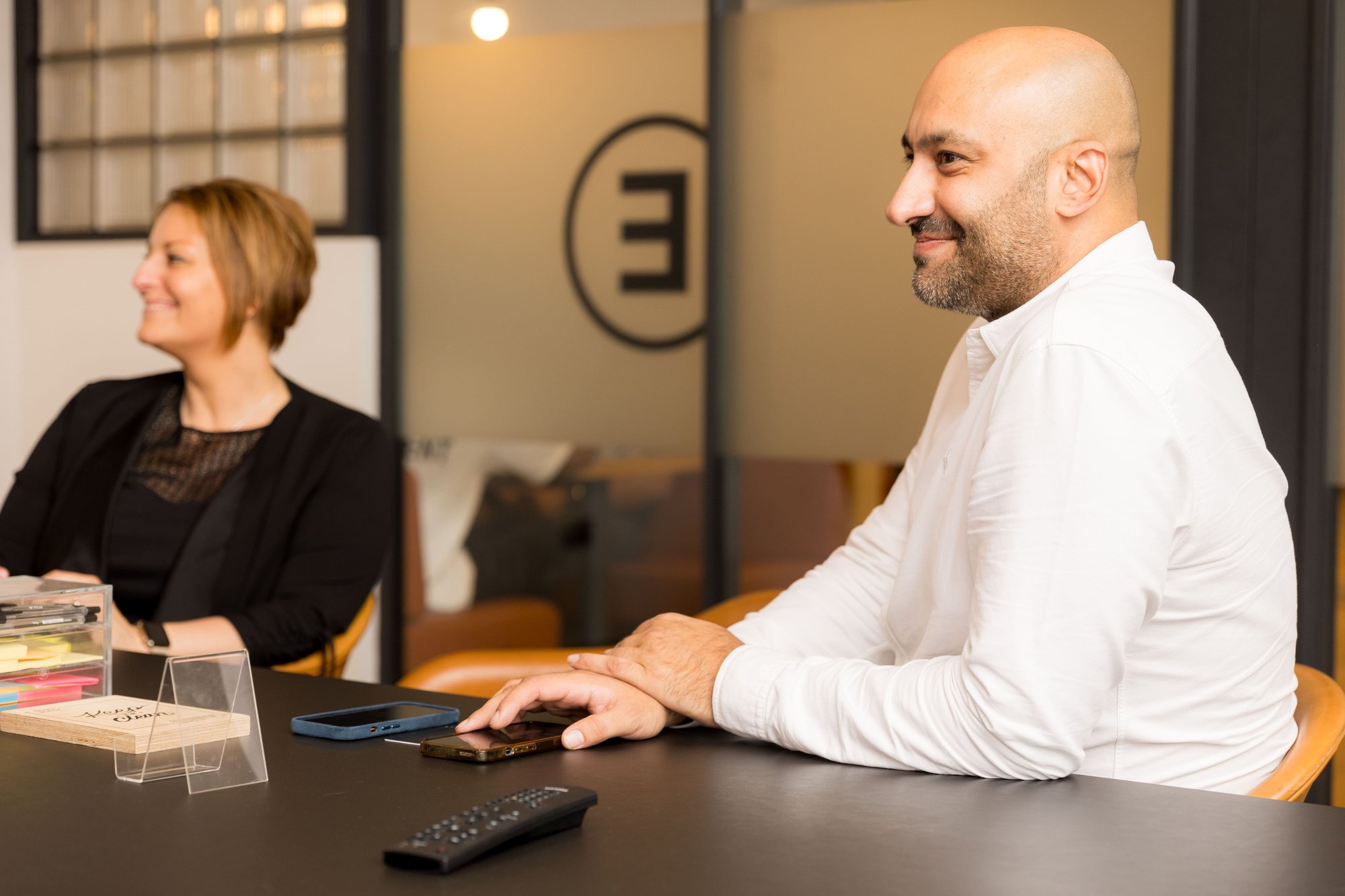 An image of two AABB employees sitting at a desk smiling. An image of two AABB employees sitting at a desk smiling.