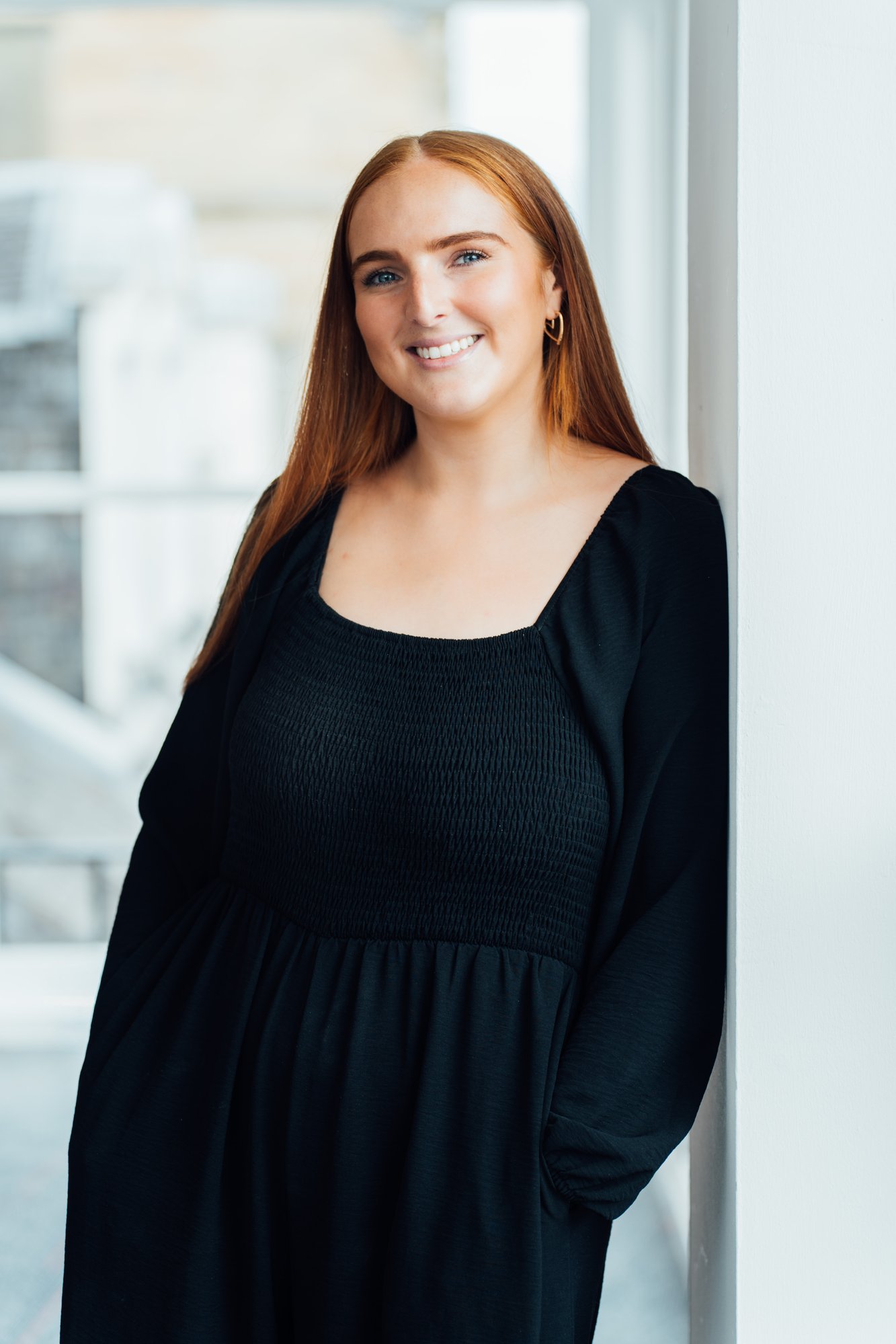 An image of Becky Weir wearing a black dress and smiling at the camera.