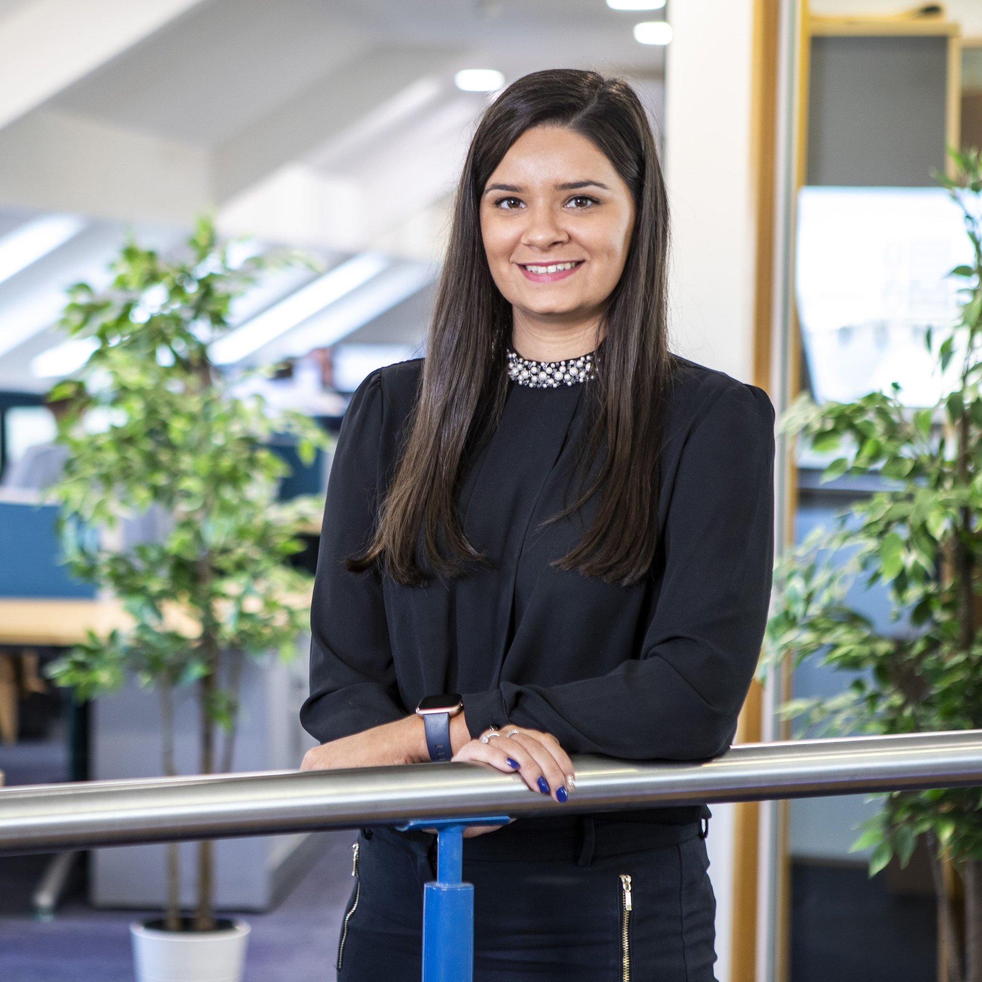 An image of Ciara standing on the balcony of an office and smiling at the camera.
