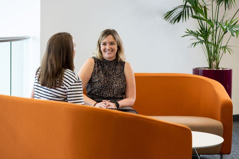 An image of two AB employees sitting in the office and chatting. An image of two AB employees sitting in the office and chatting.