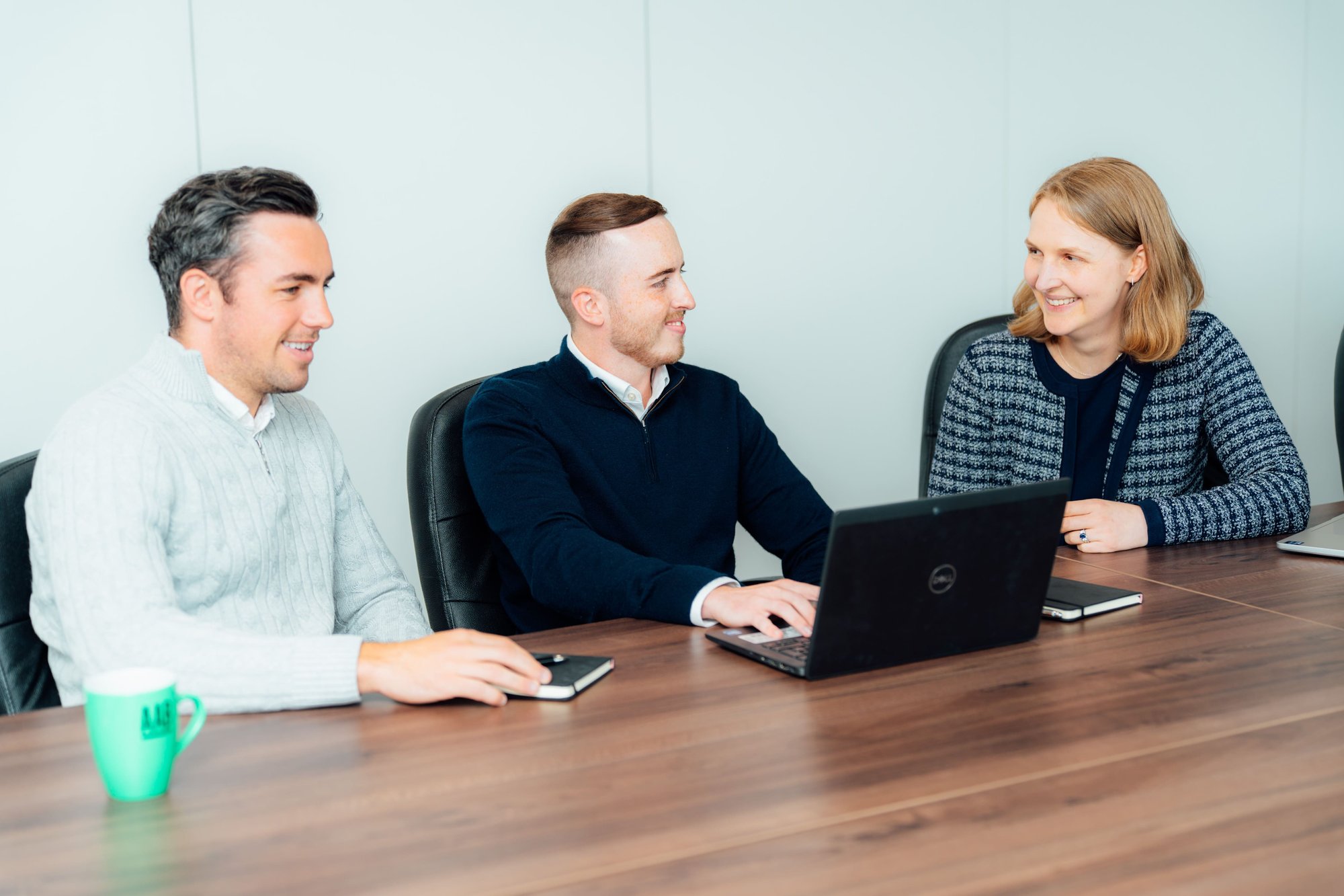 An image of Daniel Lightbody, Lewis Handley, Erica Fitchie sitting at a table with their laptop and having a conversation.